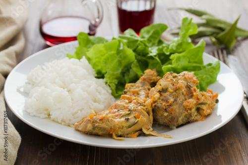 rabbit with sauce,  boiled rice and salad on plate