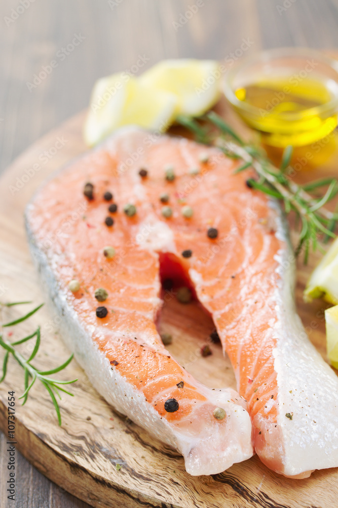 raw salmon with lemon and rosemary on wooden board raw salmon with lemon and rosemary on wooden board