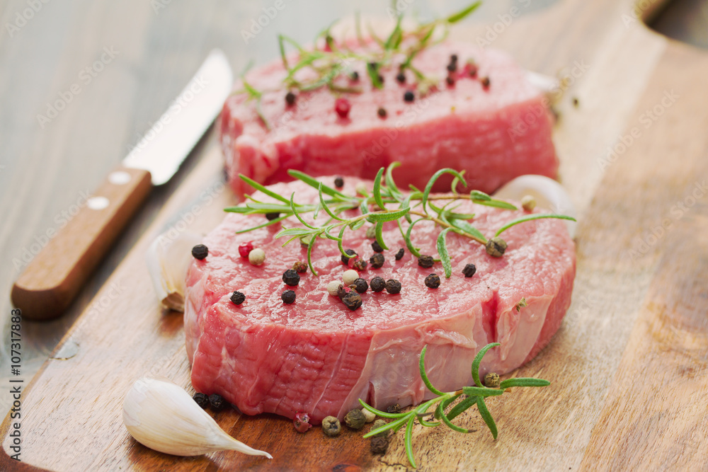 raw meat with pepper and garlic on wooden board raw meat with pepper and garlic on wooden board