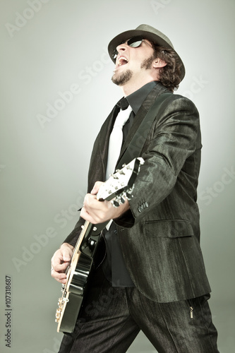 funny guitar player in concert isolated on grey