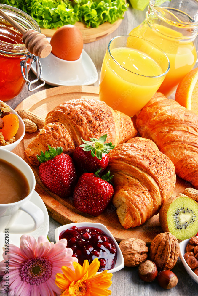 Breakfast consisting of croissants, coffee, fruits, orange juice Breakfast consisting of croissants, coffee, fruits, orange juice