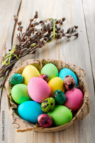 Colorful Easter eggs in the basket with willow branches
