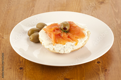 a plate of slice bagel with salmon and olives