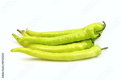 Stack of green chili peppers, on white background.
