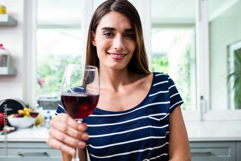 Portrait of smiling young woman holding red wine glass Portrait of smiling young woman holding red wine glass