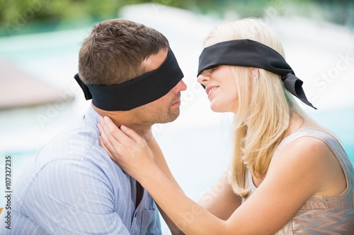 Blindfolded couple kissing 