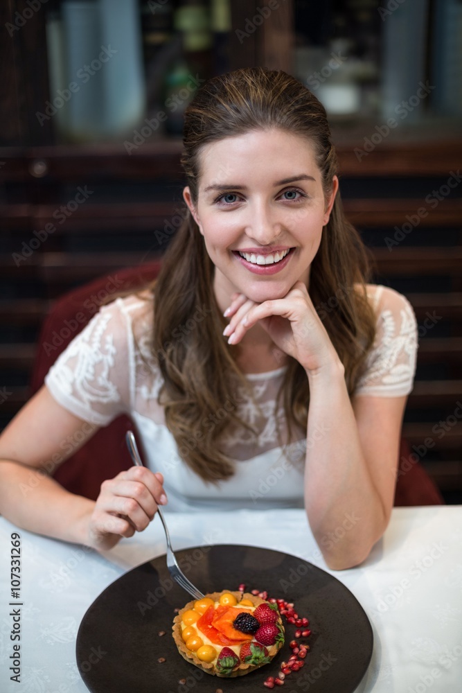 High angle portrait of happy woman with tart on table