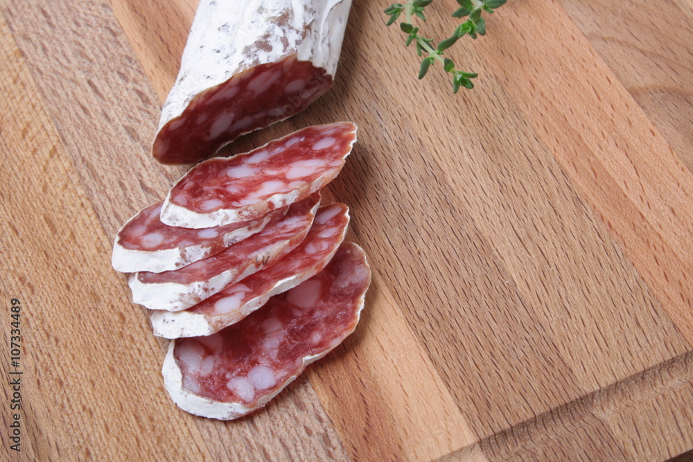 salami slicing with thyme on board