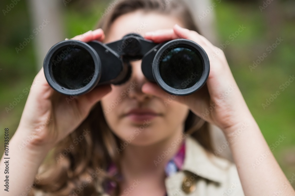 Woman using binoculars in the countryside Woman using binoculars in the countryside