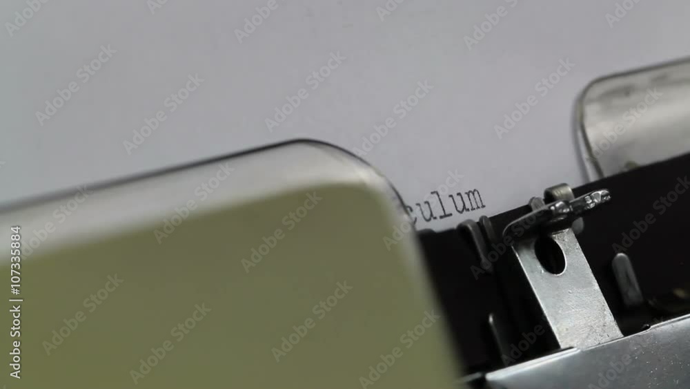 Starting a new CV on a typewriter, typing Curriculum Vitae slowly letter by letter before pushing the line up and centering it