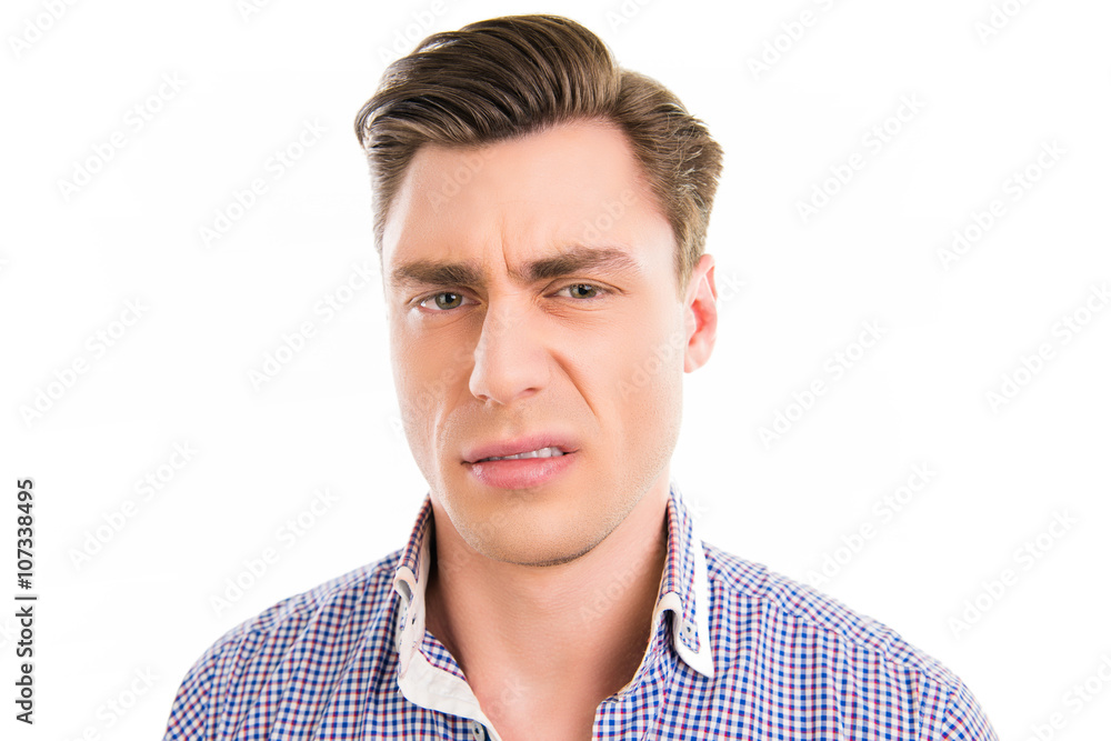 Close up photo of handsome man with unhappy grimace on his face Close up photo of handsome man with unhappy grimace on his face