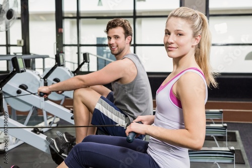 Portrait of a man and woman working out on rowing machine