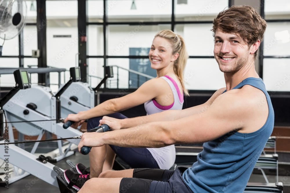 Portrait of a man and woman working out on rowing machine Portrait of a man and woman working out on rowing machine