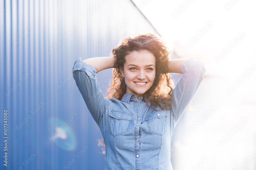 Beautiful young woman palying outdoor with curly hair Beautiful young woman palying outdoor with curly hair