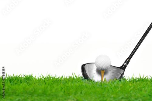 Golf ball on tee in front of driver isolated on white background 