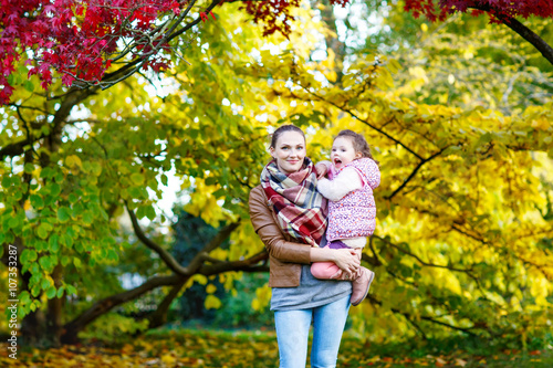 mother and her little daughter at beautiful autumn park