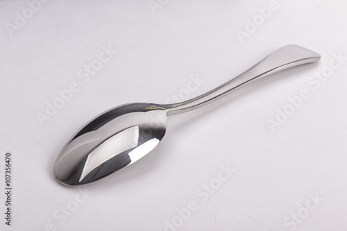 Stainless steel kitchen dessert spoon isolated over the white ba