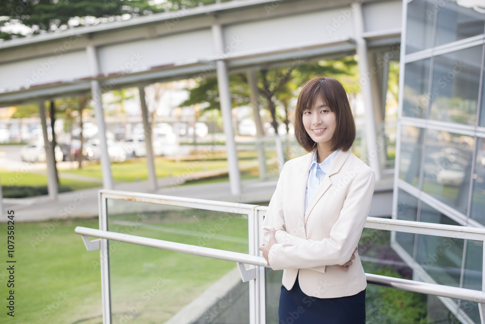 Attractive asian business woman smiling outside office