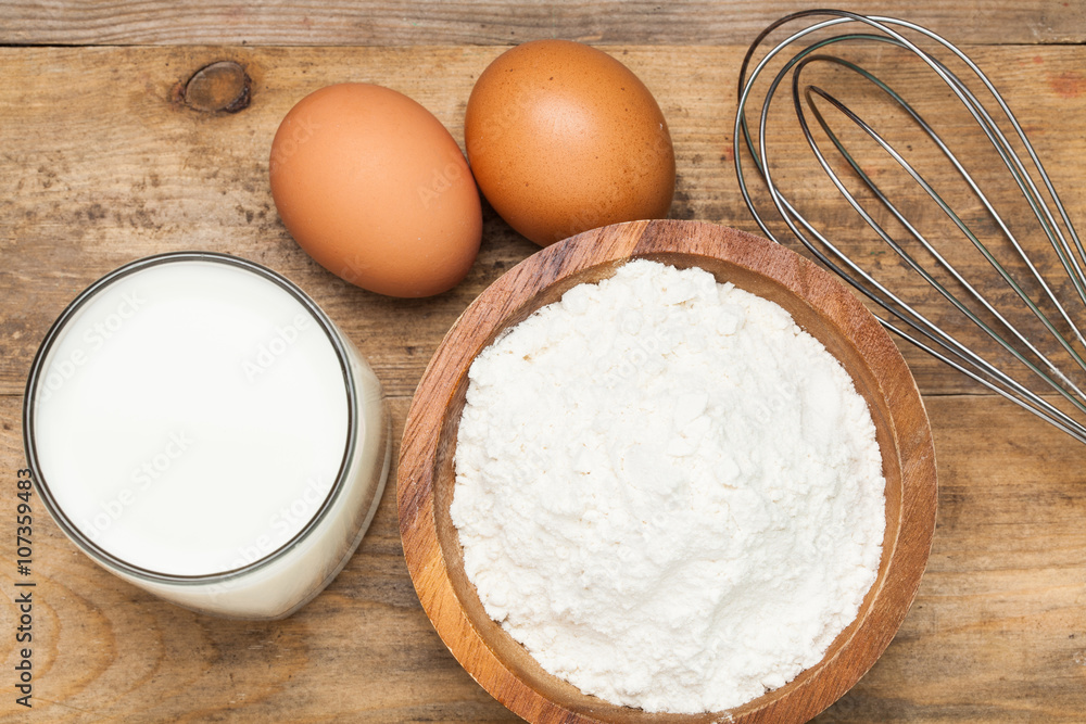 Eggs,flour, milk on a wooden worktop Eggs,flour, milk on a wooden worktop