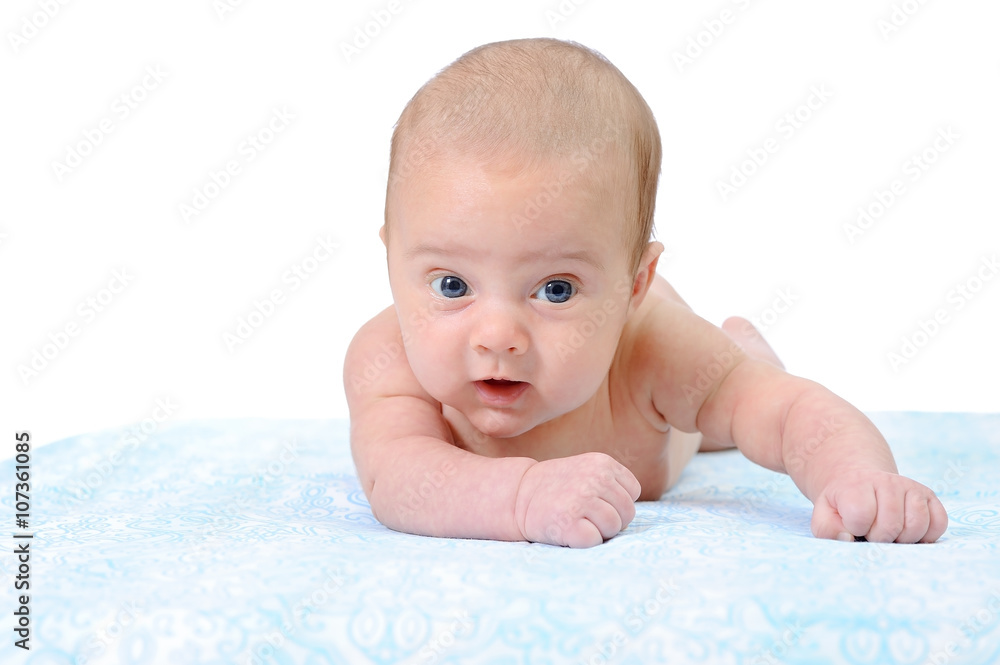Portrait of a Newborn Baby Trying to Crawl on a Blue Blanket