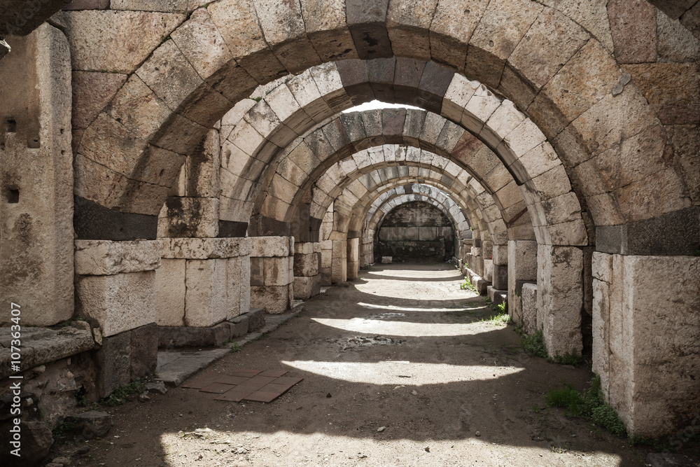 Empty stone corridor with arcs and columns
