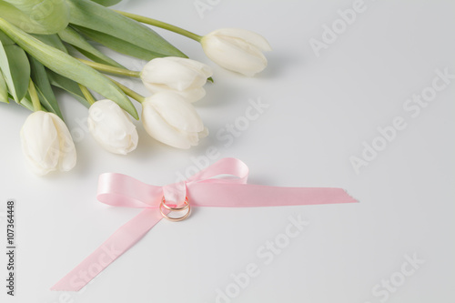 Golden wedding rings over pink ribbon