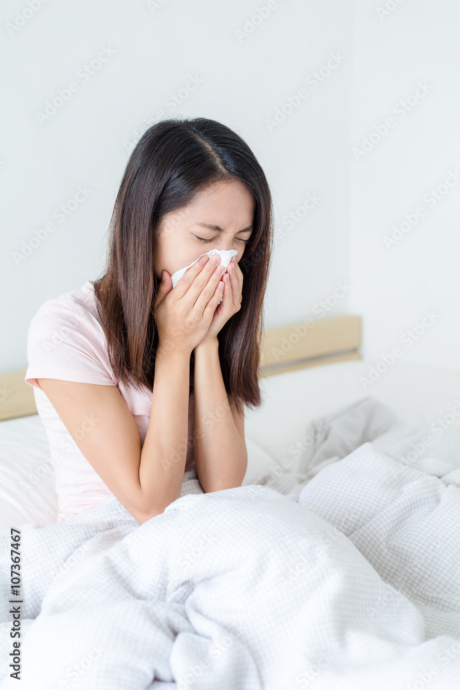 Woman sneeze and sitting on bed Woman sneeze and sitting on bed