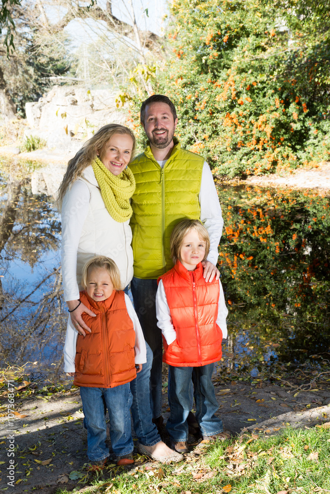 Family with two children standing near a lake. Fall Family with two children standing near a lake. Fall