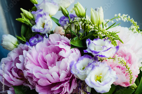 Rich bunch of pink peonies peony and lilac eustoma roses flowers. Rustic style  still life. Fresh spring bouquet  pastel colors. Background.