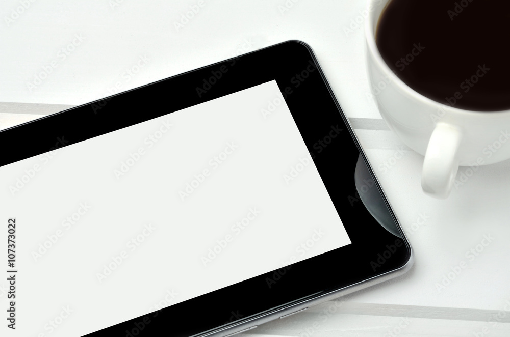 Tablet pc with cup of coffee on table Tablet pc with cup of coffee on table