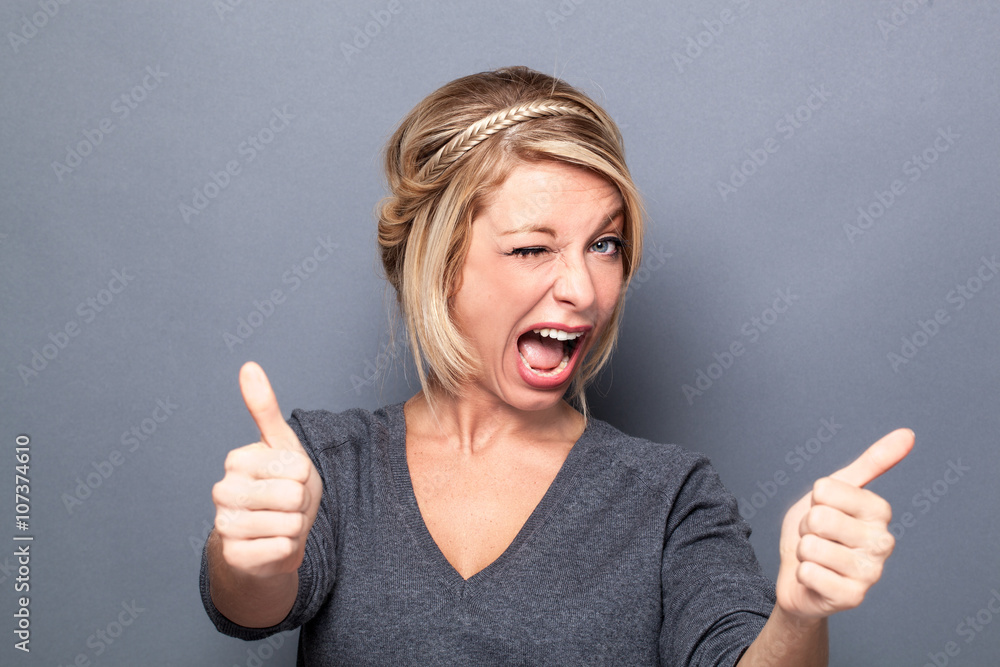 wink and seduction concepts - flirting young woman winking and smiling for cool attitude, gray background studio wink and seduction concepts - flirting young woman winking and smiling for cool attitude, gray background studio