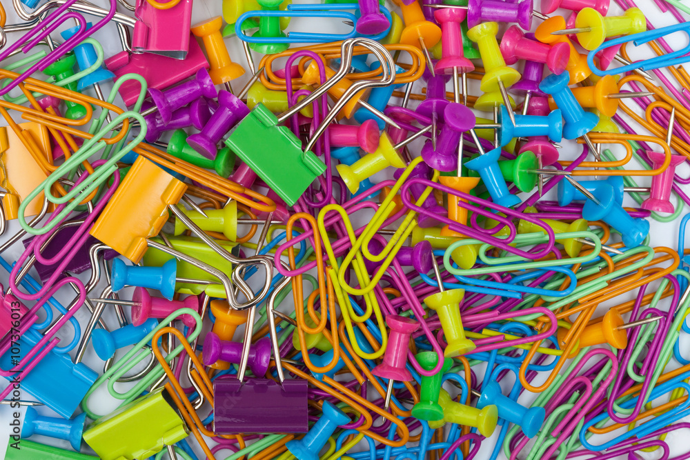 Fototapeta premium Colorful office supplies - thumb tacks, paper clips and paper clamps