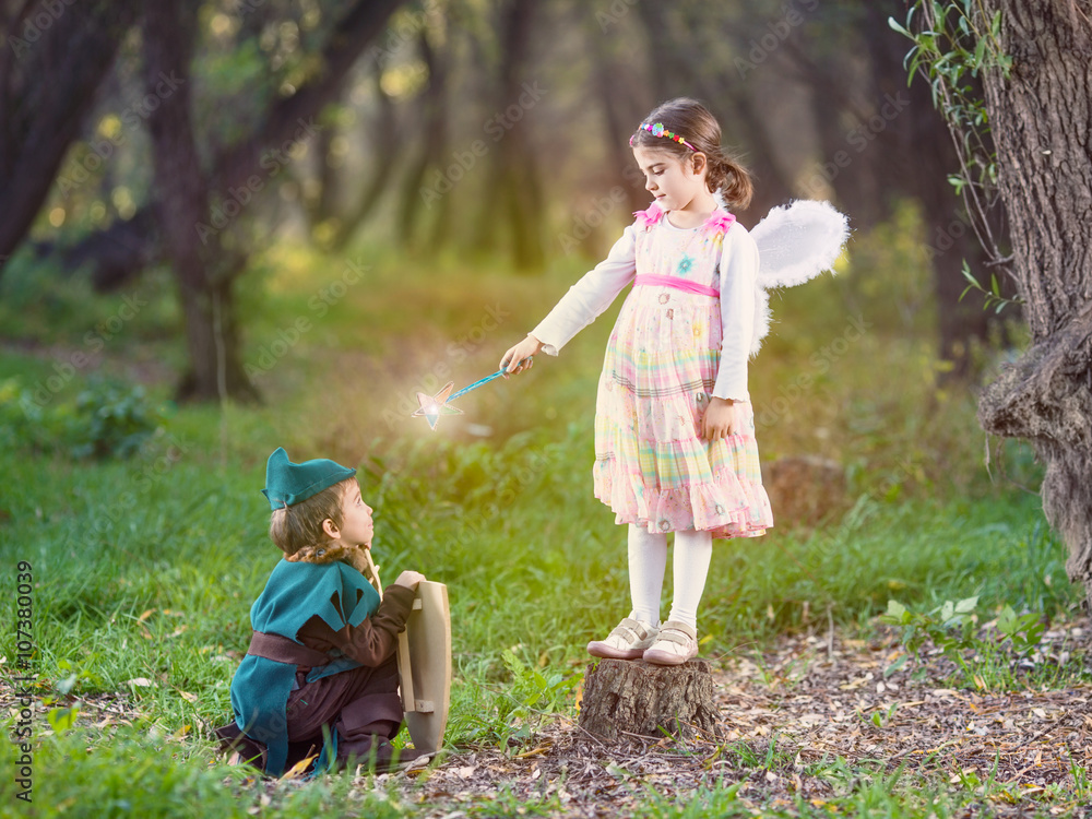 Cute little children dressed up as a fairy and a knight playing in a dreamlike nature - obrazy, fototapety, plakaty 