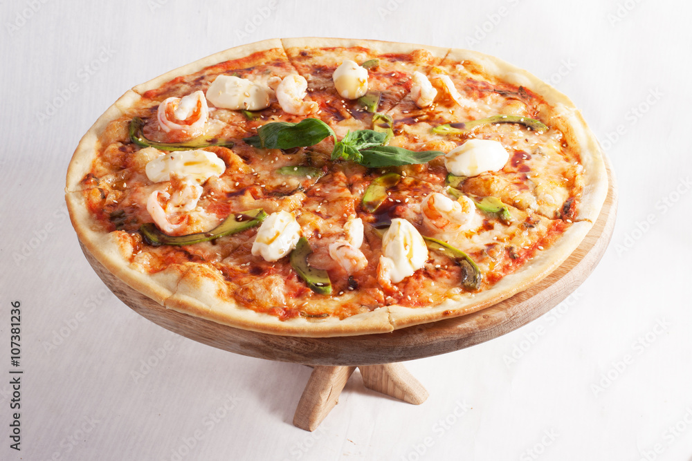 pizza with mozzarella, avocado, shrimp, sesame and basil top on a white background closeup