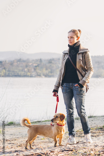 Woman and her dog enjoining by the river