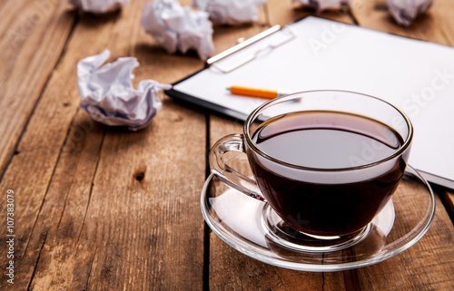 Crumpled paper balls with pencil and clipboard on wooden background  cup of coffee  a wrong idea  business concept