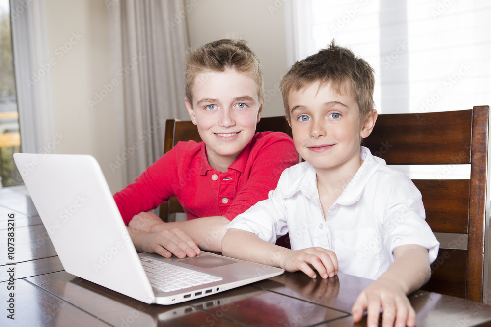 happy children boys looking at laptop indoors happy children boys looking at laptop indoors