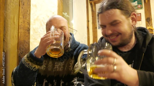 Two men drinking beer in a bar and having fun. 4K UHD