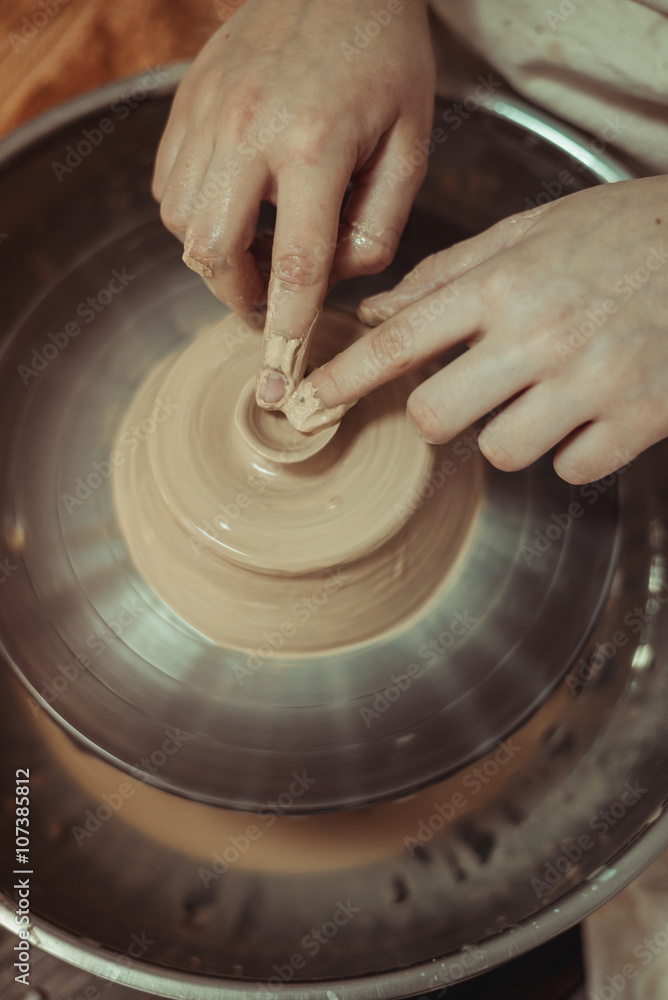 Fototapeta premium child working on potter's wheel