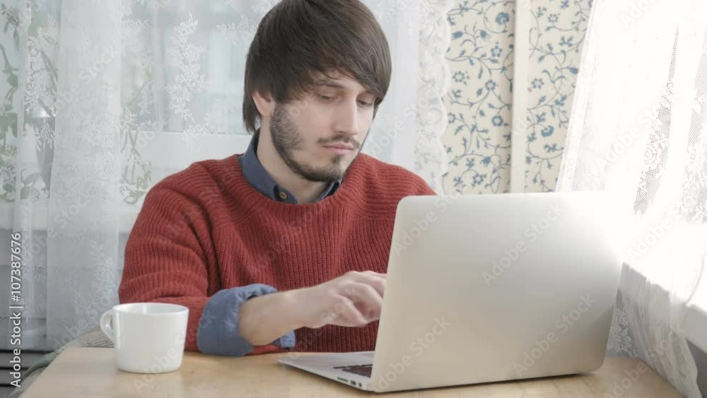 Happy Young Man Freelancer with Modern Laptop in Cafe taking Cup of Coffee Happy Young Man Freelancer with Modern Laptop in Cafe taking Cup of Coffee