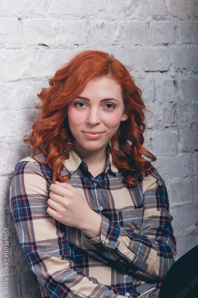 Happy young girl sitting over brick wall Happy young girl sitting over brick wall