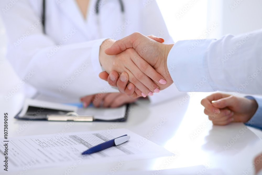 Doctor and patient handshaking. Hands close-up Doctor and patient handshaking. Hands close-up