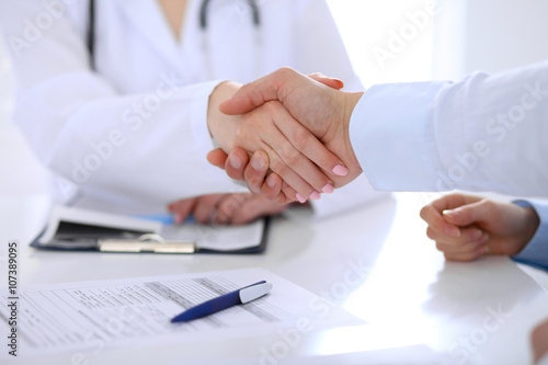 Doctor and patient handshaking. Hands close-up