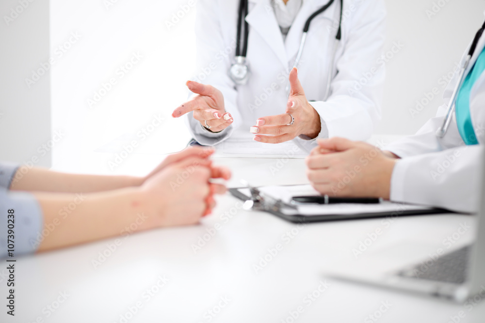 Doctor and patient are discussing something, just hands at the table Doctor and patient are discussing something, just hands at the table