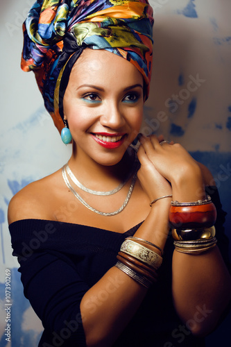 beauty bright african woman with creative make up, shawl on head like cubian closeup smiling photo