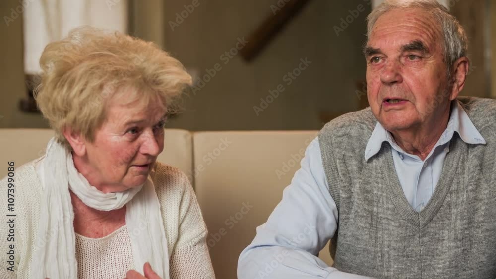 Senior couple on sofa have a discussion Senior couple on sofa have a discussion