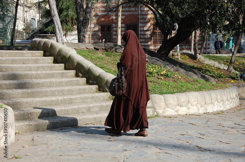 A muslim woman in traditional clothes  jilbab goes on the street