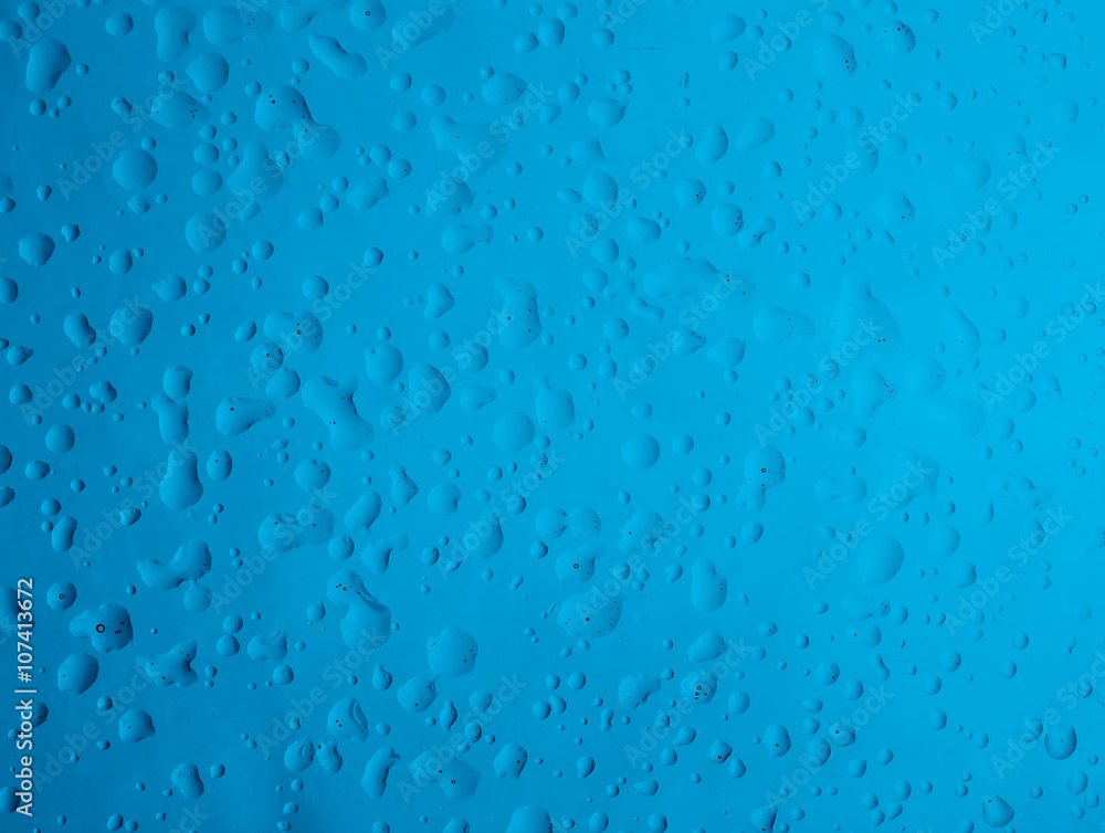 Texture water drops on the blue bottle close-up as a background. Texture water drops on the blue bottle close-up as a background.
