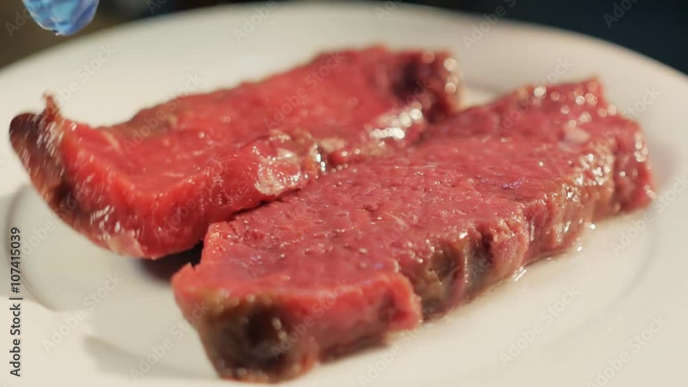 Cook peppering raw juicy meat steaks in oil Cook peppering raw juicy meat steaks in oil