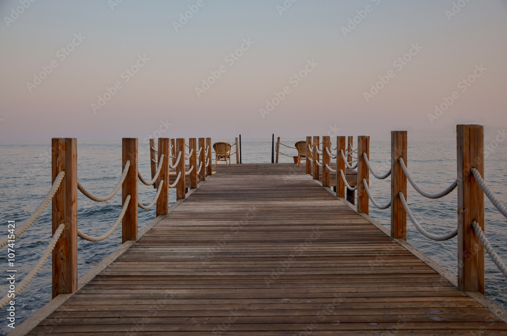 wooden pier on the coast of Aegean sea at sunrise  
Yalikavak bay, Bodrum, Turkey